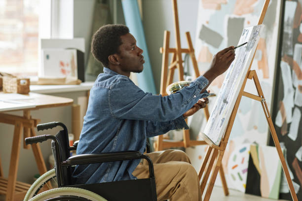 istock Young man with disability painting masterpiece on canvas 1442832564
