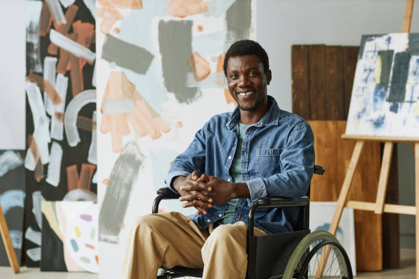 istock Happy young creative man with disability sitting in wheelchair 1442832604