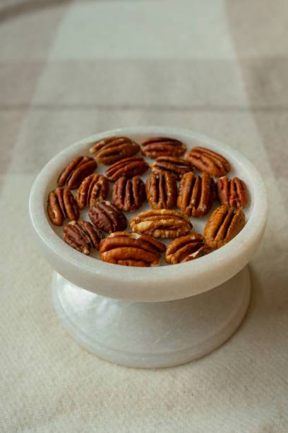 istock Walnut plan, pecan halves on a beautiful stand, Nuts are healthy. 1442835251
