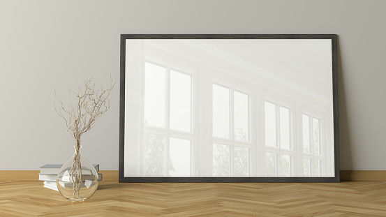 Horizontal poster frame mock up on the floor in living room with wooden floor and white wall. 3d illustration