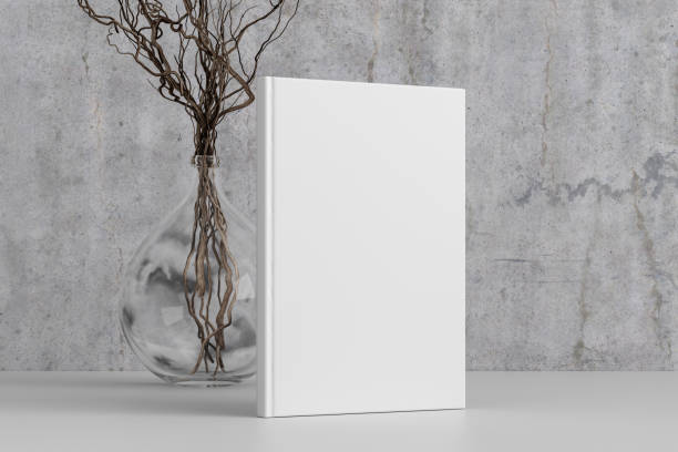 istock Vertical  book cover mock up standing on a white desk with concrete wall background. 1442836534