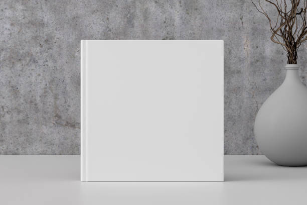 istock Square book cover mock up standing on a white desk with concrete wall background. 1442836551
