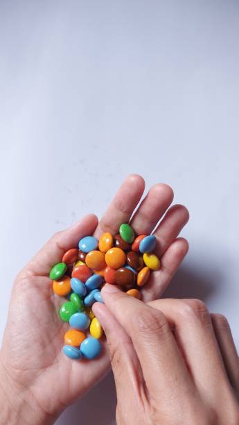 istock Women hand hold colorful chocolates. 1442840115