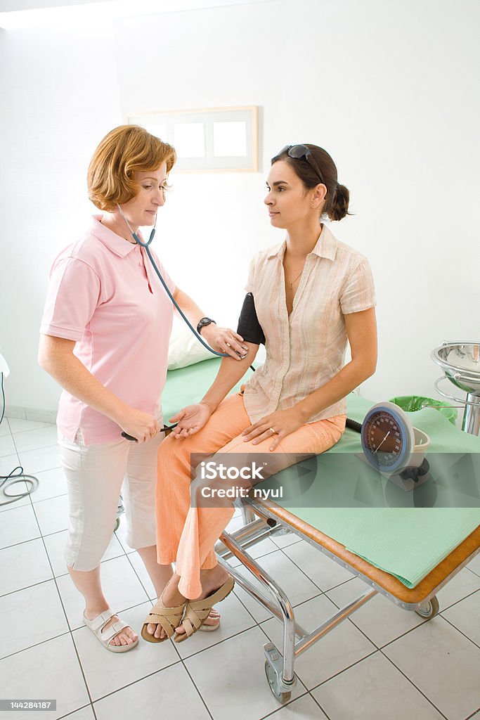 measuring blood-pressure Nurse measuring the patient's blood-pressure. Blood Pressure Gauge Stock Photo