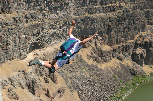 A brave extreme sports (BASE Jumping) enthusiast jumps off the Perrine Bridge into the Snake River Canyon.