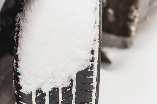 Car wheel close-up. Car under snow. Winter weather. Climate. Storm. Transportation