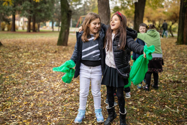 Happy kids having fun after environmental cleanup at public park stock photo