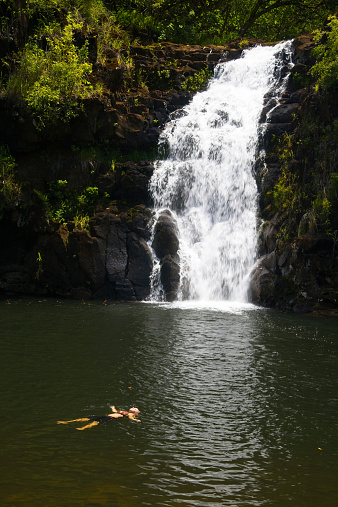A young teenager floating near Waimea falls, Hawaii.