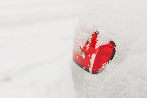 Car lights close-up. Car under snow. Winter weather. Climate. Storm. Transportation