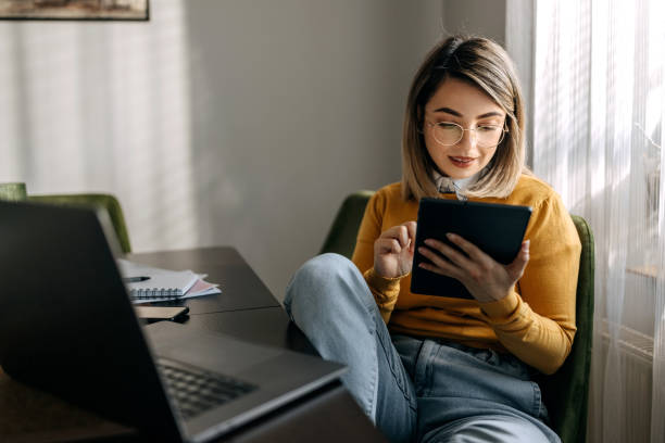 istock Young well dressed businesswoman using digital tablet while working from home 1442860861