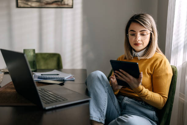 istock Young well dressed businesswoman using digital tablet while working from home 1442860937