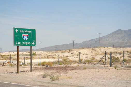Landscape view of the route 15 sign with arrows pointing to Barstow and to Las Vegas.