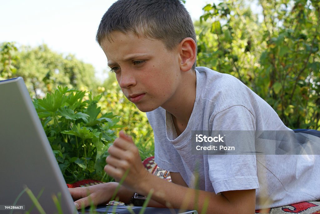 Work on a computer In a garden with a laptop. Adolescence Stock Photo