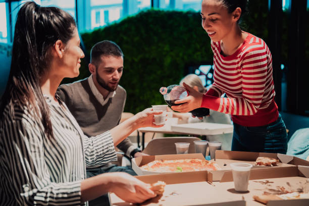 istock Eating pizza with diverse colleagues in the office, happy multi-ethnic employees having fun together during lunch, enjoying good conversation, and emotions 1442866423