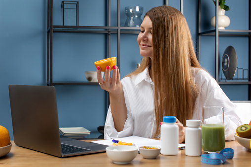 A young specialist in dietetics advises an online client and makes an appointment for taking vitamins and dietary supplements. Various supplements on the doctor's table. Healthy nutrient