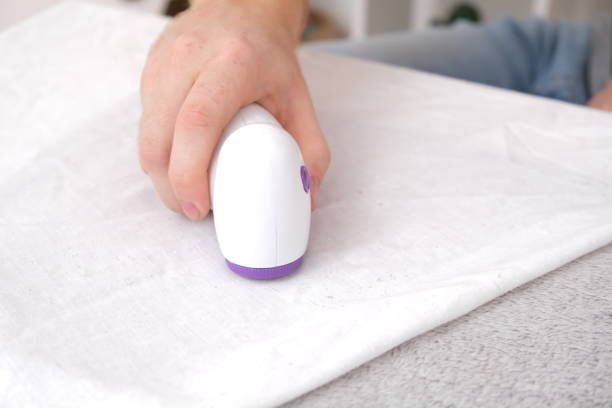 istock man removes fabric pills using lint shaver. 1442867897