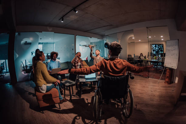 istock Business persons with a disability at work in modern open space coworking office on team meeting using virtual reality goggles. 1442869600
