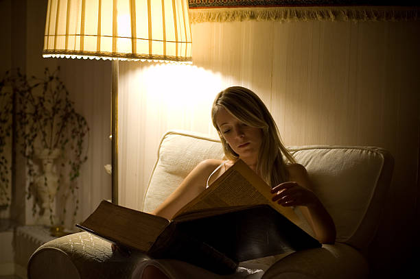 istock Girl reading a big book in a comfortable room 144287299