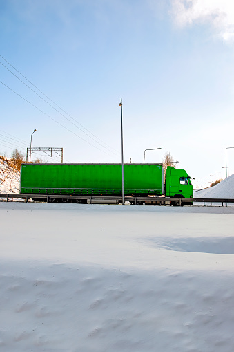 Truck entering the tunnel against blue sky and winter landscape