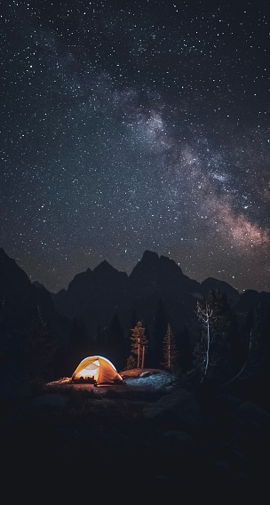 A tent in the mountains under the stars