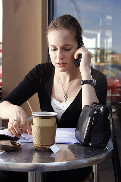 Young woman doing paperwork at cafe stock photo