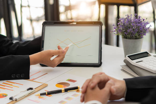Business consultants analyze financial figures showing the progress of financial business, accounting, contracts, investment advisory Consulting company marketing plans using tablets and technology. los consultores de negocios analizan las cifras financieras que muestran el progreso de los negocios financieros, contabilidad, contratos, asesoría de inversiones consultoría de planes de marketing de la empresa utilizando tabletas y tecnología.