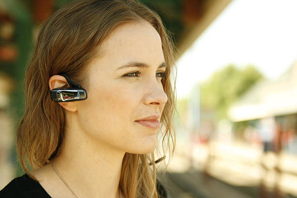 Young woman using bluetooth headset stock photo