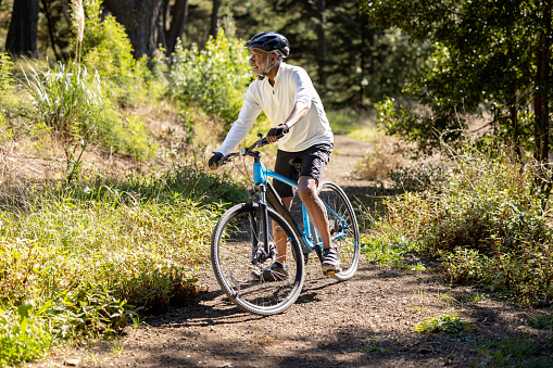 High quality stock photos of an African American man exercising and riding a bike outdoors in a wooded area on a trail and off.