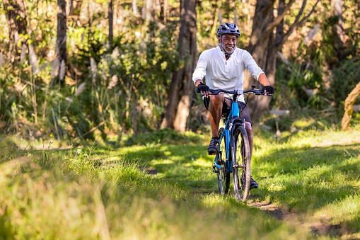 High quality stock photos of an African American man exercising and riding a bike outdoors in a wooded area on a trail and off.