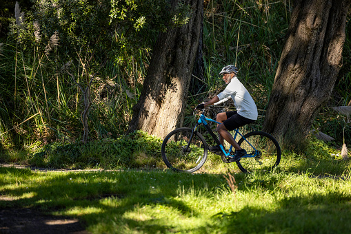 High quality stock photos of an African American man exercising and riding a bike outdoors in a wooded area on a trail and off.