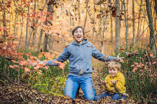 Happy smiling family relaxing in autumn forest.