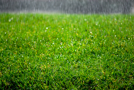 Rain drops on window glass outside texture background water of wonderful heavy rainy day with sky clouds at city blue green blurred lights abstract view sunshine enjoy the relaxing nature wallpaper