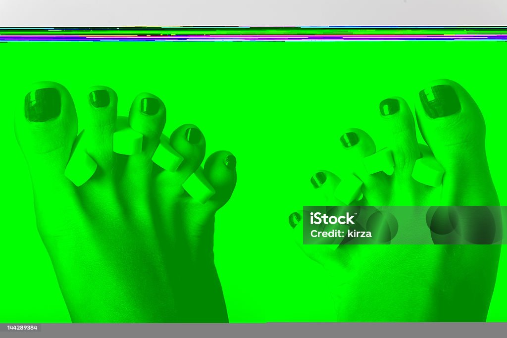 Green effect background of Feet with toe pads Feet during the pedicure, isolated on grey Activity Stock Photo