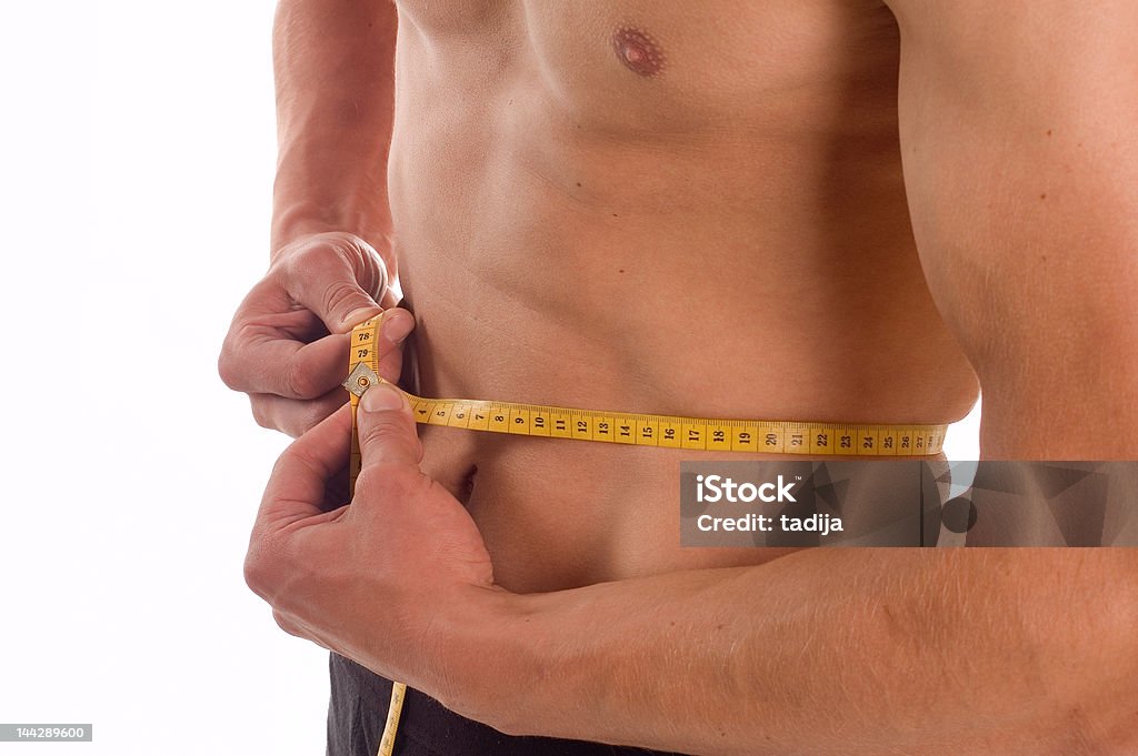 Measuring Young pretty man measuring his perfect body isolated on white Abdomen Stock Photo