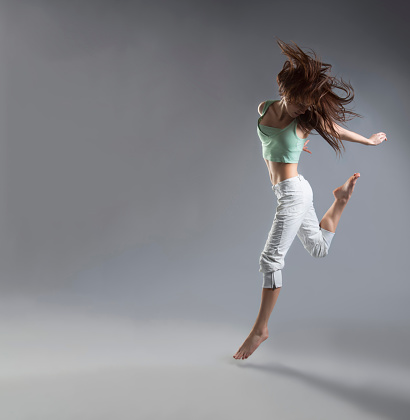 beauty girl dance on grey background. person jumping, flying in the air