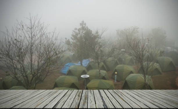 Empty Table on Blur Camping Tent in Forest with Weather Fog in Dawn Backgound,Lifestyle Tourist travel Outside Vacation Summer Nature Plant Growth Tree in Holidays,Sunset in Park Autumn Season.