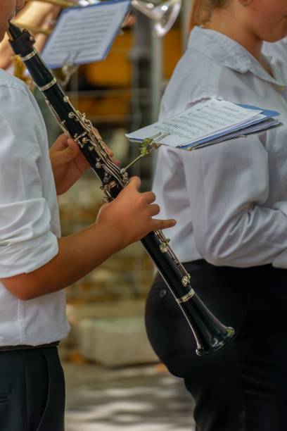 unrecognizable man playing clarinet in an orchestra