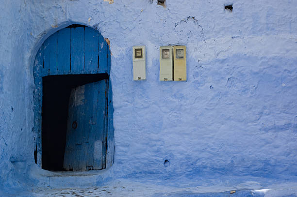 Małe drewniane drzwi w mur z niebieski liczników energii elektrycznej – zdjęcie