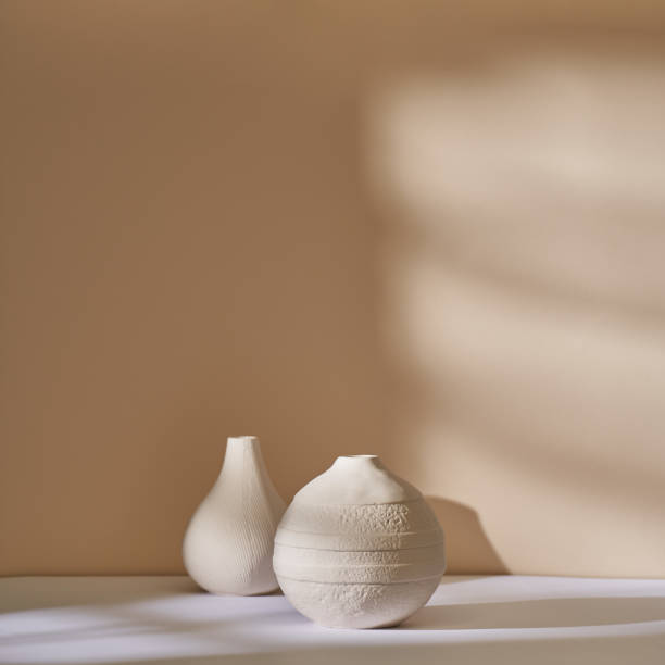 istock Couple of minimalistic ceramic pots against a beige wall 1442903501