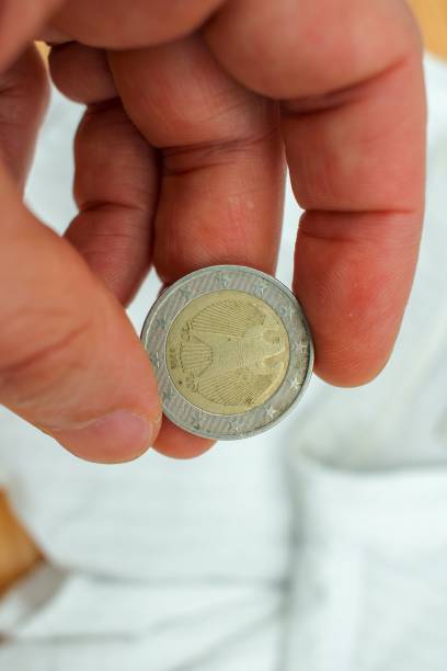 istock a two euro coin from Germany between my fingers 1442903734