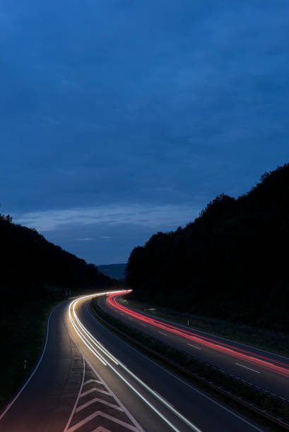 istock Long exposure of traffic light trails between forested hills during the blue hour 1442903807