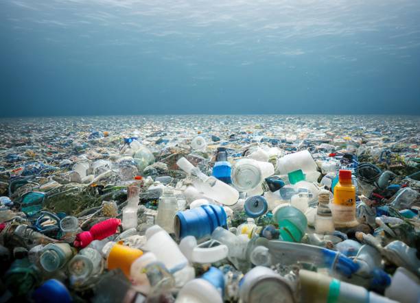 sparo di rifiuti di plastica nell'oceano. inquinamento idrico. - plastic foto e immagini stock