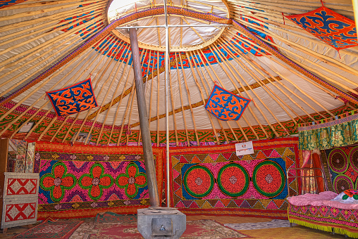 Yazd, Iran - April 7, 2018: Local man arranges the fringes of Persian carpet in the bazaar in Yazd, Iran