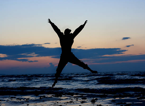 Man jumping near sea. stock photo