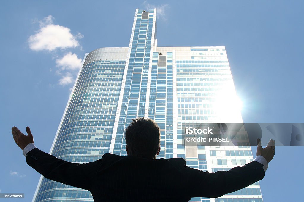 ビジネスマン腕を上げるの超高層ビル - スーツ��のロイヤリティフリーストックフォト