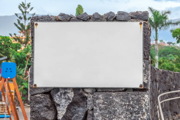 Mockup of a laminated poster screwed to a stone wall with screws in a city park in Puerto de la Cruz, Spain stock photo