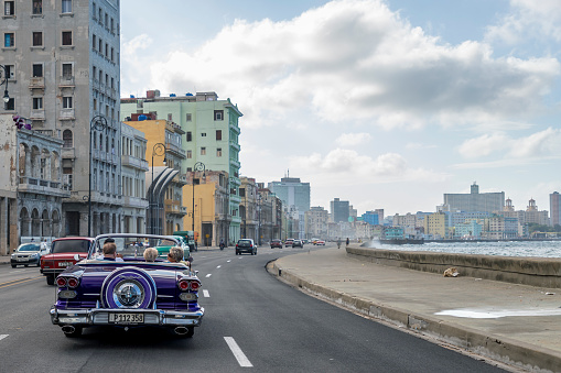 Havana, Cuba – December 03, 2019: An American convertible car from the 50s moving through Malecon street in Havana, Cuba