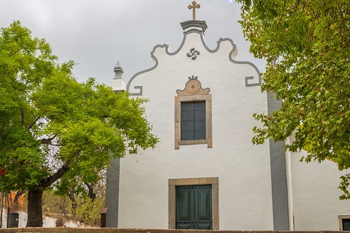 Tall mission style church in a city.