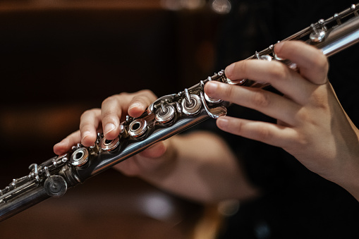 A closeup of hands of a musician playing the flute