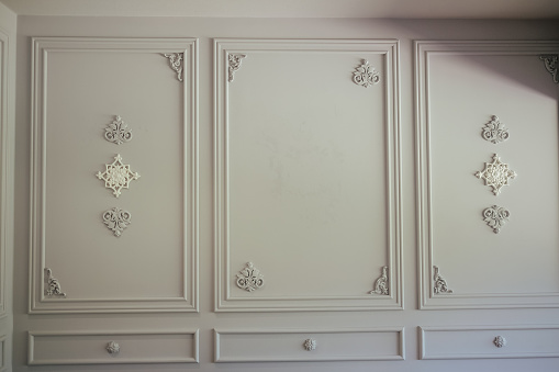 A closeup of white boiserie panels in art deco style